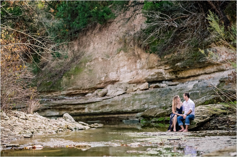 Engagement Photoshoot with Couple Sitting in Creek Austin Texas natural light photographer