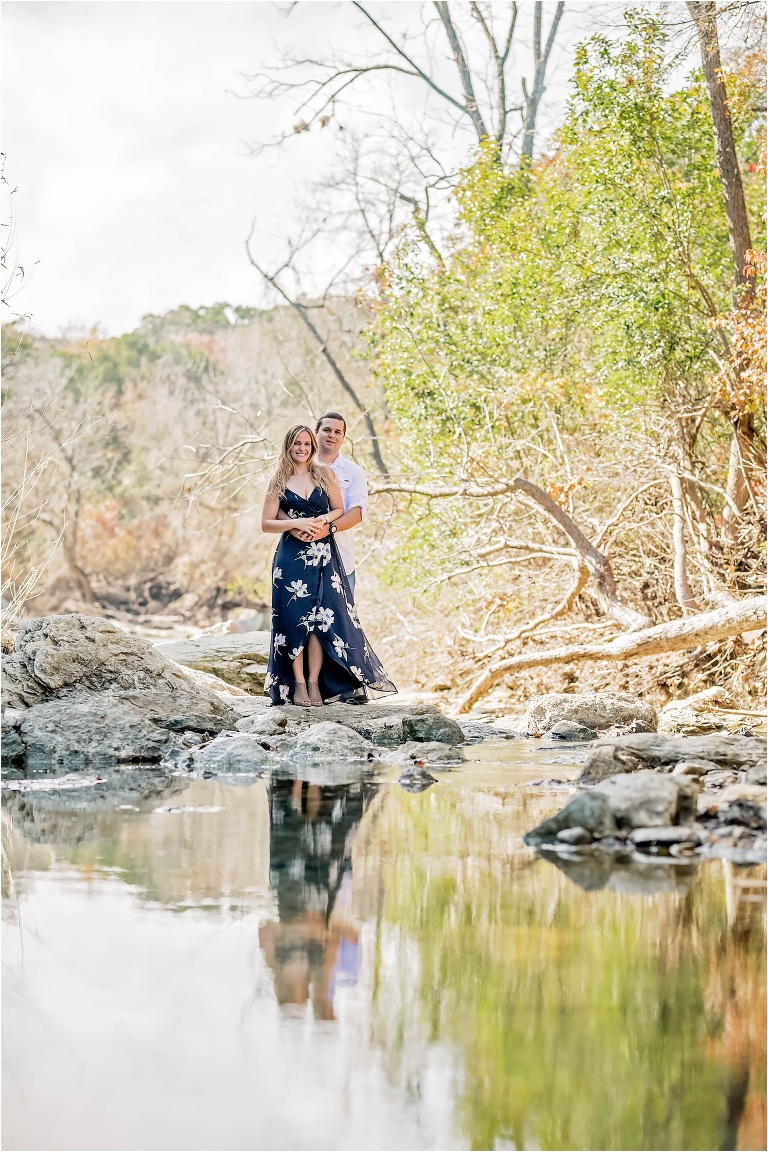 Engagement Photoshoot with Couple standing in Creek in Austin Texas Reflection Photograph Natural Light Photographer