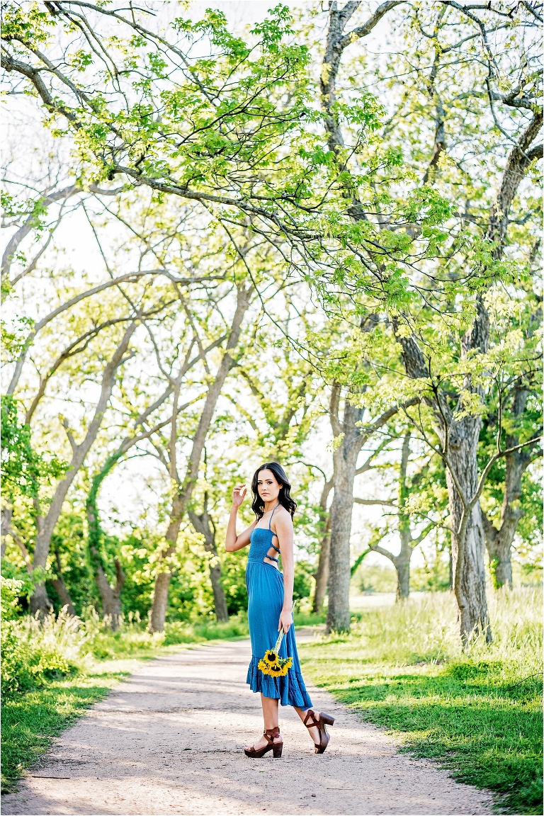 Senior Portrait Girl walking down path with Sunflowers in blue dress Georgetown Texas Photographer