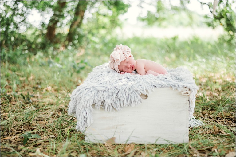 Newborn Photoshoot in Austin Texas Baby Girl on grey blanket with tan bow Natural light Photographer Round Rock