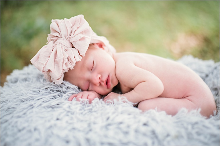 Newborn Photoshoot in Austin Texas Baby Girl on grey blanket with tan bow Natural light Photographer Round Rock