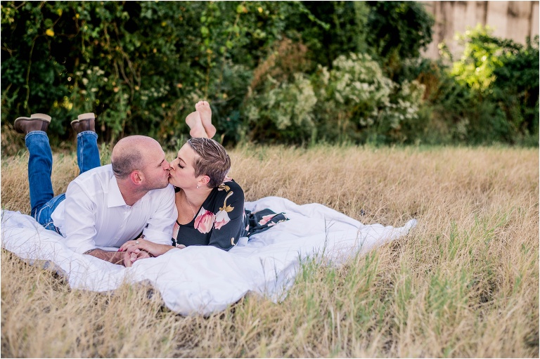 Couple in field kissing in Georgetown Texas during natural light portrait photoshoot