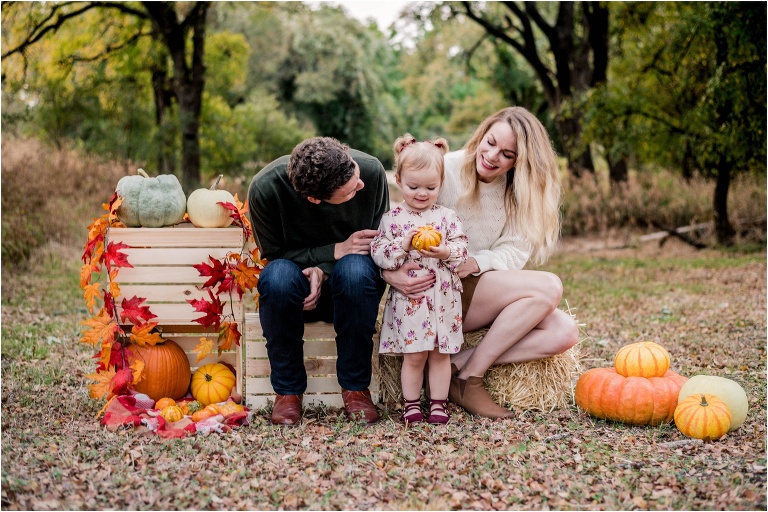 mother and father with little girl during Fall Mini Photoshoot in Cedar Park Texas by natural light family photographer located in Austin TX