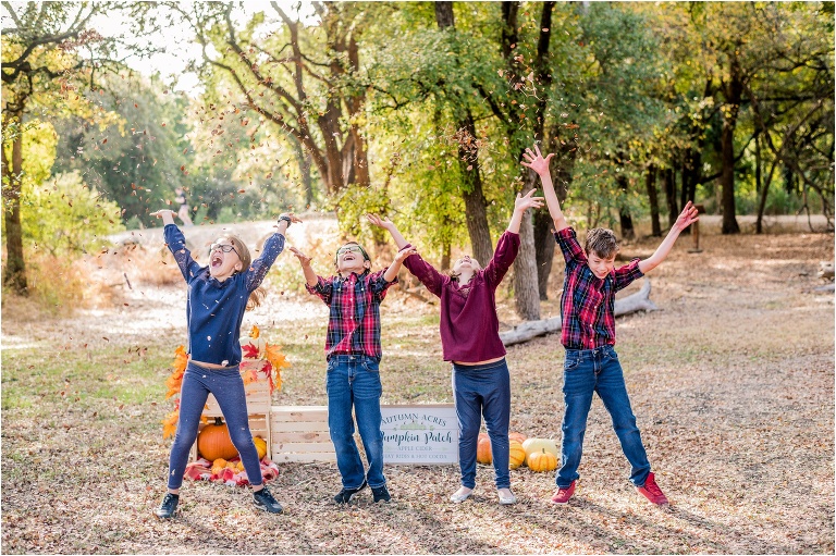 Fall family mini sessions kids throwing leaves in Cedar Park