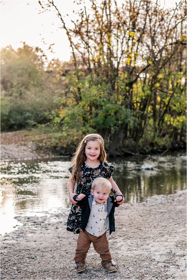 Brother and sister by creek in Cedar Park Texas during family photoshoot by natural light children portrait photographer