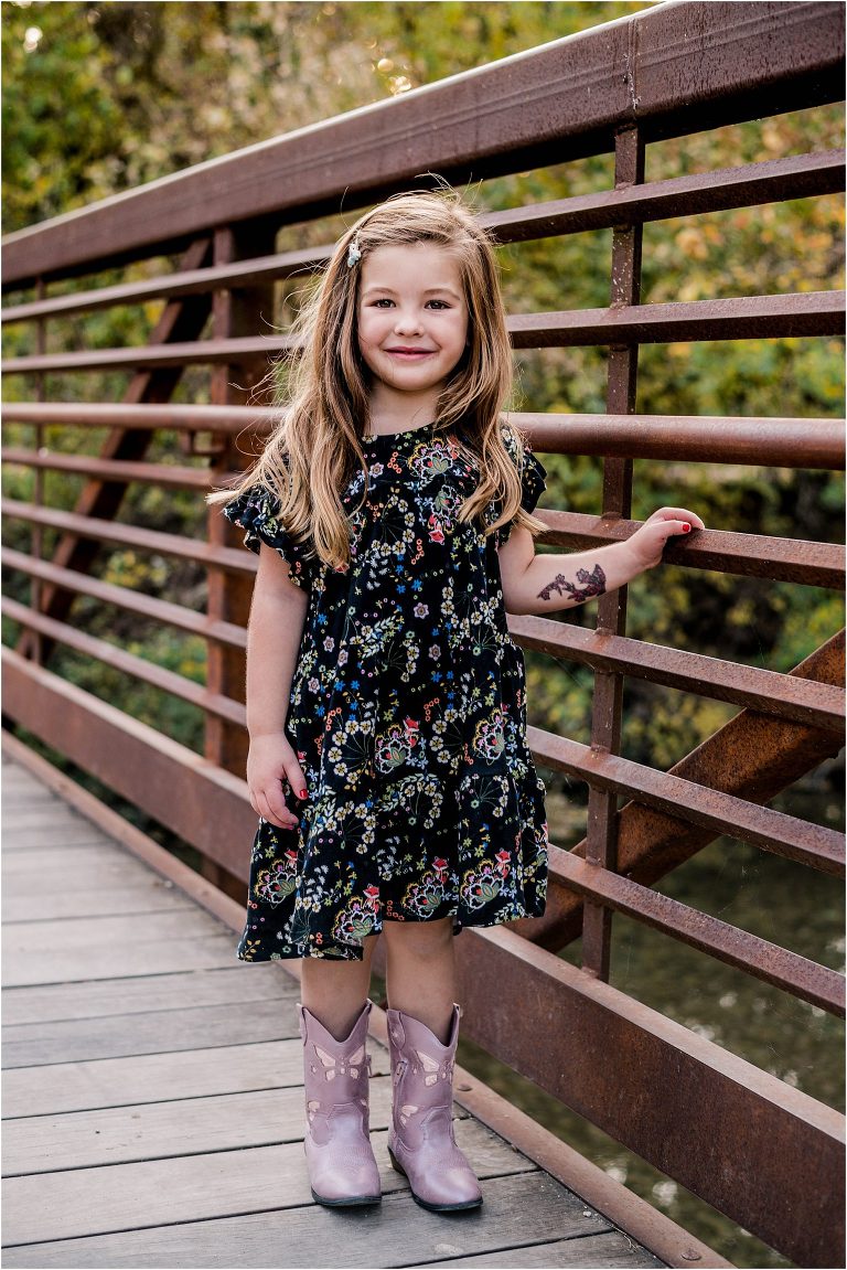 Little girl on bridge during Christmas family photoshoot in Cedar Park Texas by portrait photographer